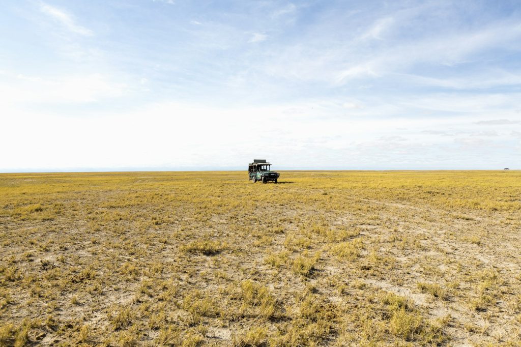 A safari vehicle on open ground in the desert.